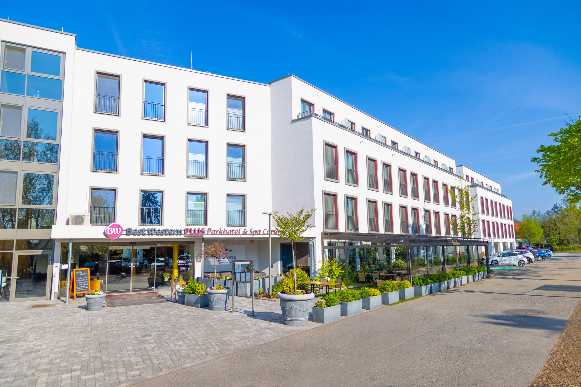 Außenansicht des Best Western Plus Parkhotel & Spa Cottbus mit moderner Architektur, großen Fenstern, Eingangsbereich und Terrasse.