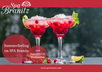 Cocktailgläser mit rotem flüssigen Inhalt. Davor liegen Himbeeren und eine viertel Limette